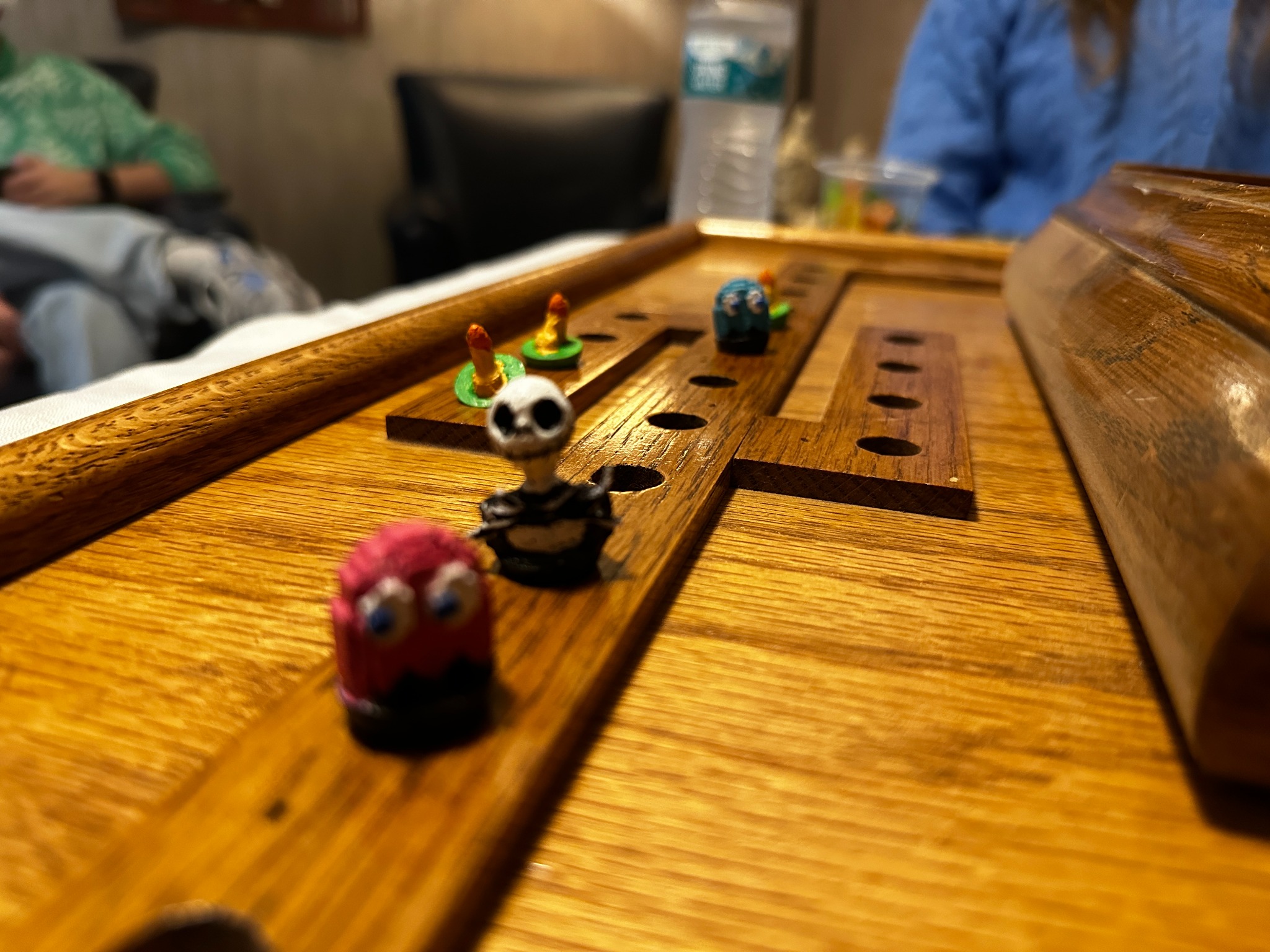 Custom painted marbles in play on handmade wooden board during family game night