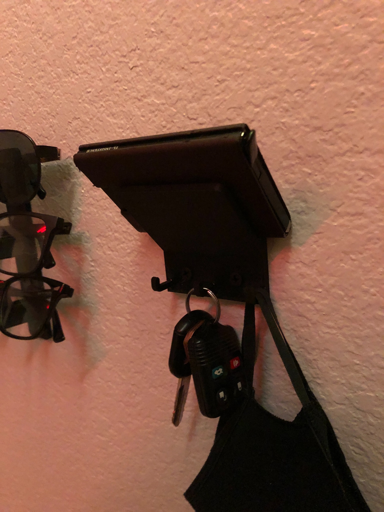 Close-up shot of installed hanger with wallet on shelf and keys hanging from hooks