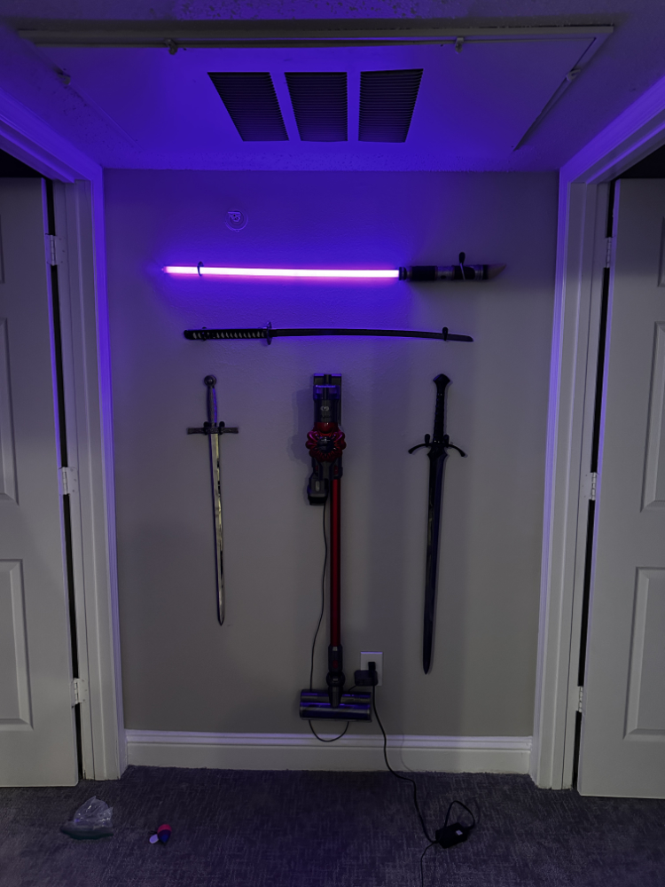 vaccum displayed in the center of swords hung up on wall